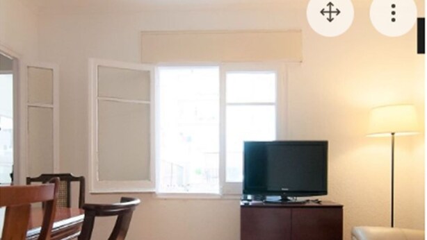 A living room with a television on a wooden cabinet, a glass coffee table, a sofa, and a dining area with chairs. - Private room (1) near the University with large terrace of 150 m2.  (Barcelona)