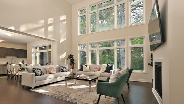 A spacious living room with a large window, a fireplace, and a dining area.