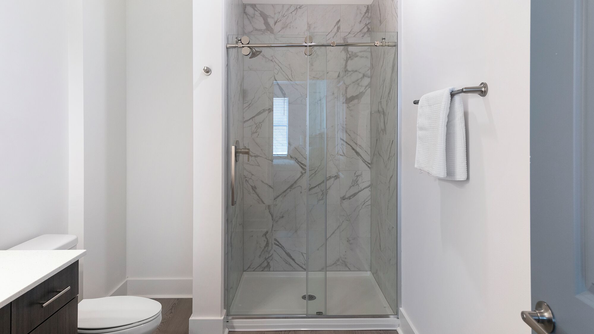 Un baño moderno con ducha de vidrio, inodoro y zona de lavamanos.