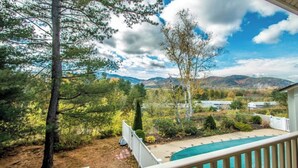 Un espace piscine offrant une vue sur les montagnes et les arbres.