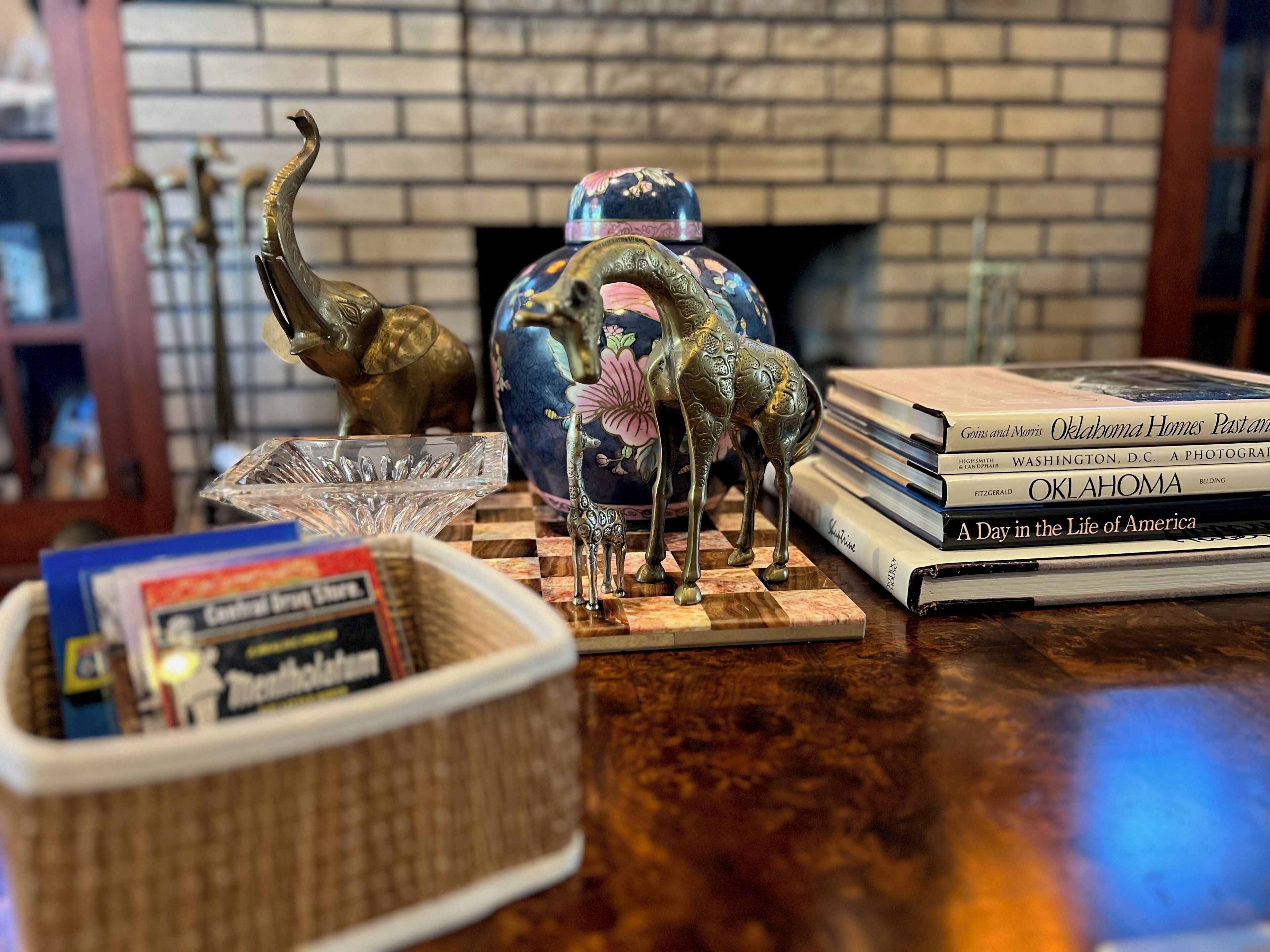 Une table en bois ornée de divers objets décoratifs, notamment une figurine de girafe, un vase et une pile de livres.