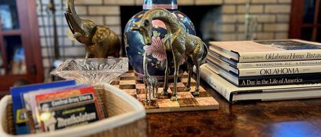 Une table en bois ornée de divers objets décoratifs, notamment une figurine de girafe, un vase et une pile de livres.