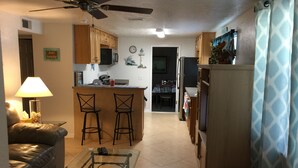 A compact living space with a kitchenette, a dining area, and a seating area with a glass coffee table. - 3-bedroom house in marvelous Hudson with AC, WiFi (Hudson)