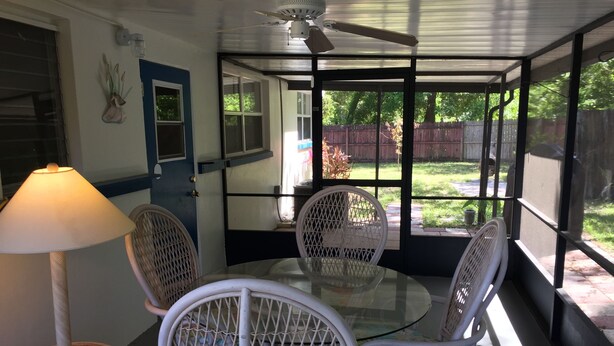 A covered patio with a table and chairs, a ceiling fan, and a view of the backyard. - 3-bedroom house in marvelous Hudson with AC, WiFi (Hudson)