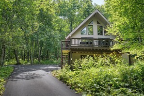 A cabin with a balcony, surrounded by dense forest. - Serenity Cabin-Woodland Retreat (Wintergreen Resort)