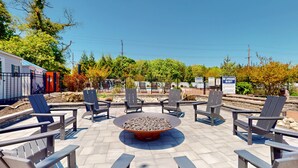 An outdoor seating area with Adirondack chairs and a central fire pit. - Two-Bedroom Suite for the Ultimate Family Vacation (Cape May)