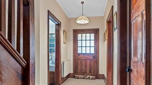 A hallway with wooden doors, a radiator, and a ceiling light fixture. - Beautiful Detached Farm House Near Lake Coniston - Pass the Keys (Torver)
