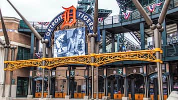 Enter the iconic Detroit Tigers stadium through a grand archway featuring the team's logo and name.