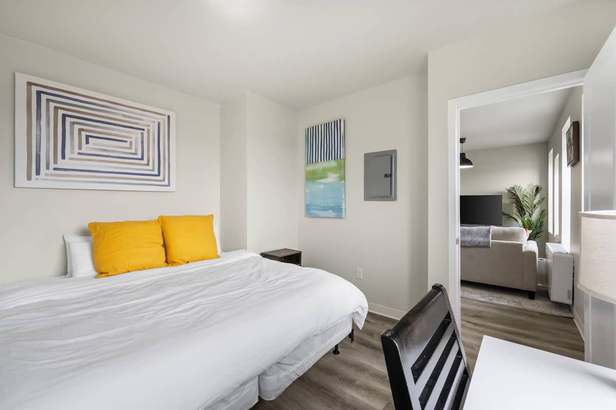 Une chambre d’hôtel moderne dotée d’un grand lit, d’un bureau et donnant sur l’espace de vie.