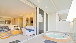 Una sala moderna con sofá, una mesa de centro y un jacuzzi.