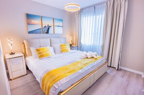 A modern hotel room with a large bed, bedside tables, a nightstand, and a view of the sea through the window. - Spacious 5-bedroom villa with AC, WiFi in vibrant Las Vegas (Las Vegas)
