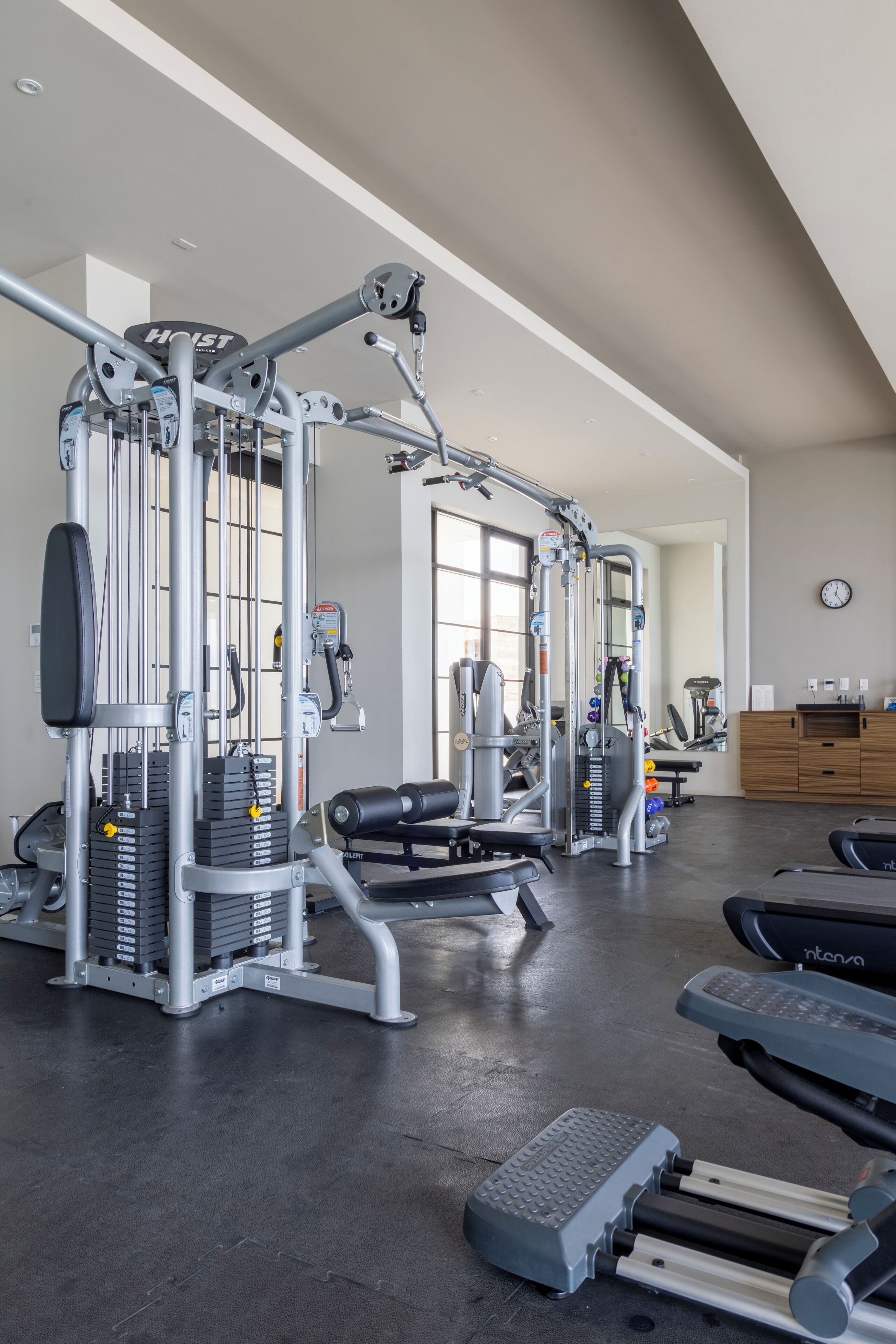 A gym with various exercise equipment, including weight machines and treadmills.