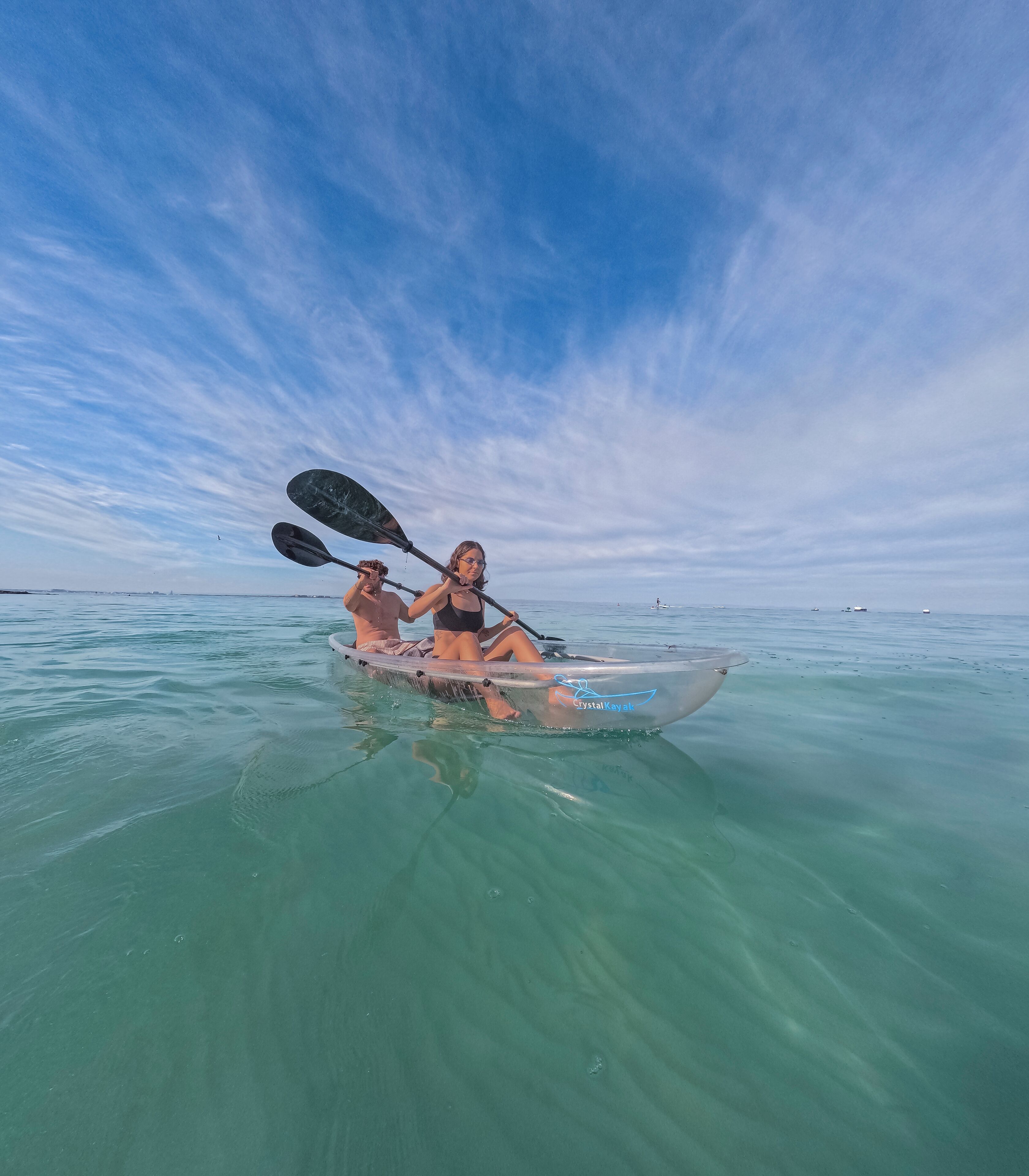 Un kayak su acque cristalline turchesi, con cielo sereno.