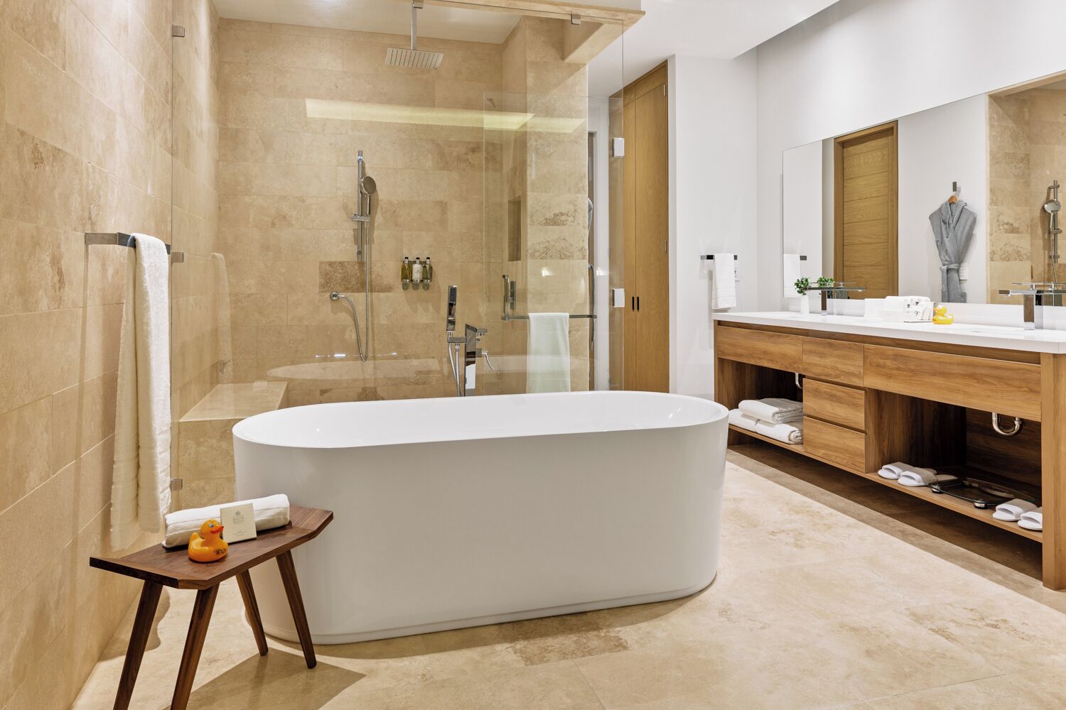 A modern bathroom with a freestanding bathtub, a glass-enclosed shower, and a wooden vanity with a mirror.