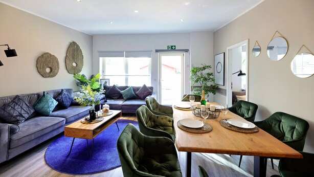 A modern living room with a sofa, coffee table, and dining table set up.