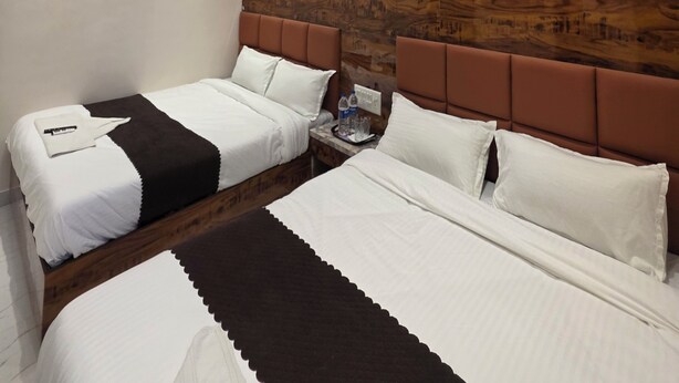 A hotel room with two beds, a ceiling fan, and a wooden headboard.