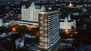 A high-rise hotel with multiple floors, surrounded by other buildings and a cityscape at night.