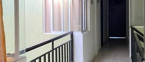 A corridor with a balcony, a potted plant, and a door marked 404.