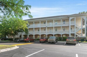 Um motel com vários andares, um pátio central, estacionamento e uma galeria coberta.