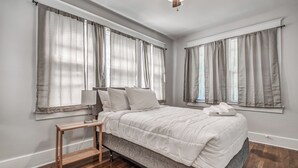 Ein Schlafzimmer mit Bett, Nachttisch und Deckenventilator.