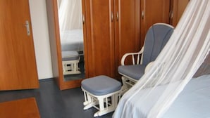 Un dormitorio con cama, una silla y un armario.