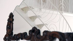 Eine Wendeltreppe mit aufwendiger Holzbalustrade und hellem Innenraum.