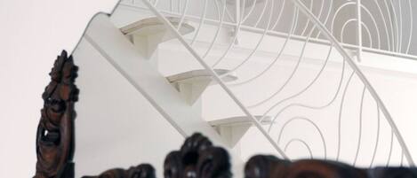 A spiral staircase with ornate wooden railings and a white interior.