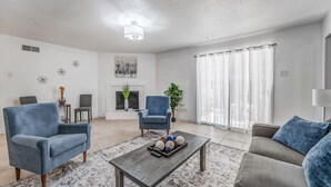 A living room with a fireplace, two armchairs, a sofa, and a coffee table with decorative items. - Near Parks Tranquil Fox Trails (Memphis)