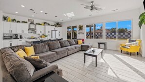 A modern living room with a grey sectional sofa, a coffee table, and a yellow armchair.