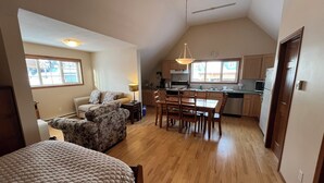 Ein gemütlicher Wohnraum mit Küchenzeile, Essbereich und Schlafzimmer.