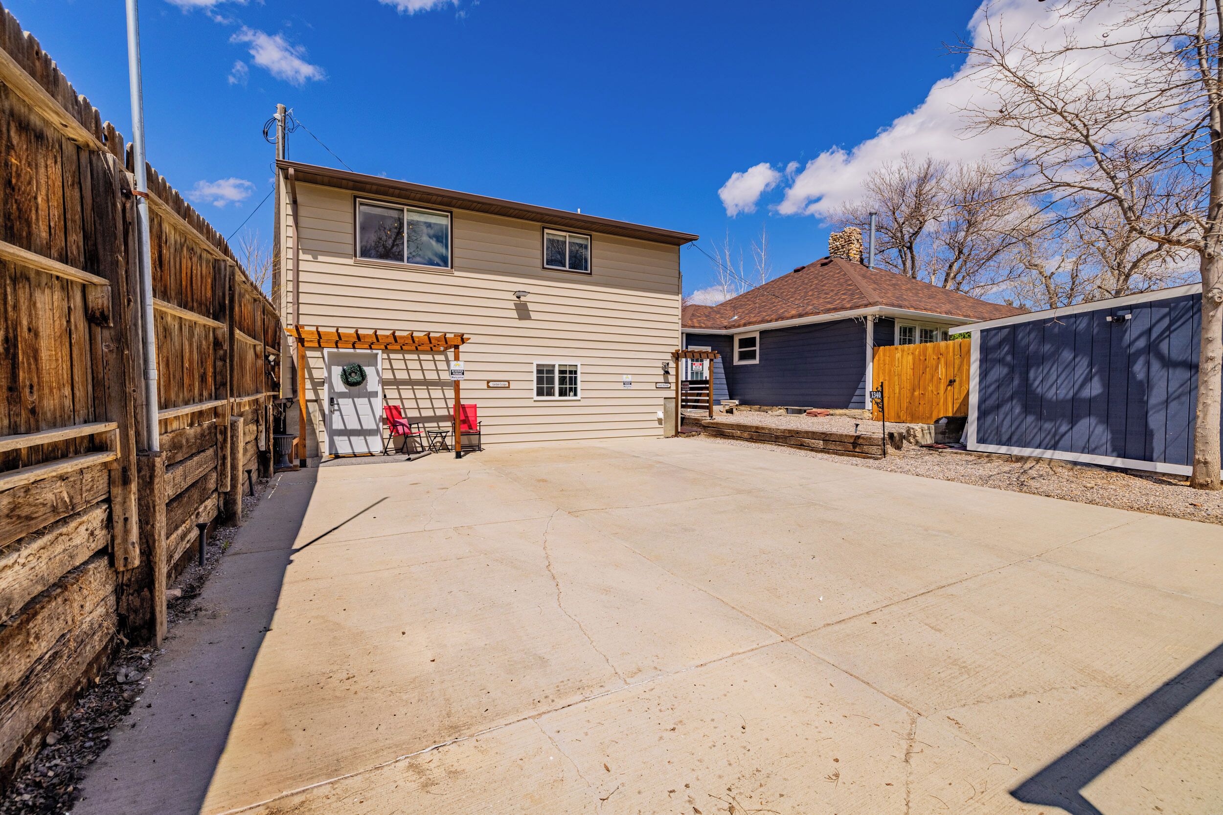 A two-story house with a covered patio area, a wooden fence, and a garage.