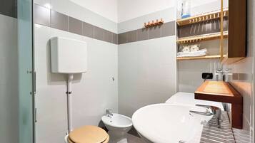 A modern bathroom with a toilet, bidet, and sink.