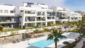 A modern hotel with multiple balconies, a swimming pool, and a landscaped garden. - Exclusive penthouse with 2 bedrooms and sea views  (Estepona)