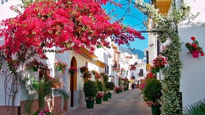 A narrow street lined with white buildings, some with balconies and flower boxes. - Exclusive penthouse with 2 bedrooms and sea views  (Estepona)