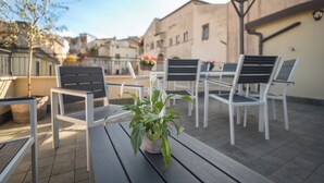 A terrace with outdoor seating, a potted plant, and a view of buildings in the background. - La Terrazza Anagni (Anagni)