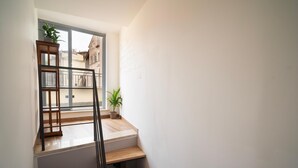A staircase with wooden steps and a metal railing, leading to a balcony with a view of buildings. - La Terrazza Anagni (Anagni)