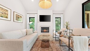 A modern living room with a fireplace, a sofa, a coffee table, and a TV mounted on the wall. - Lakefront Wellness Retreat on Table Rock w/ Sauna, Cold Plunge, Hot Tub, Gym (Omaha)