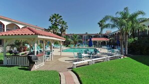 A pool area with lounge chairs and a gazebo. - Beach Across the Street, Shared Heated Pool, Pet Friendly (Corpus Christi)