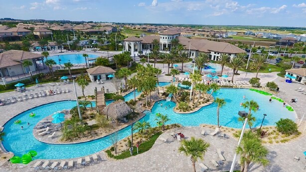 A resort with multiple swimming pools, palm trees, and lounge areas.
