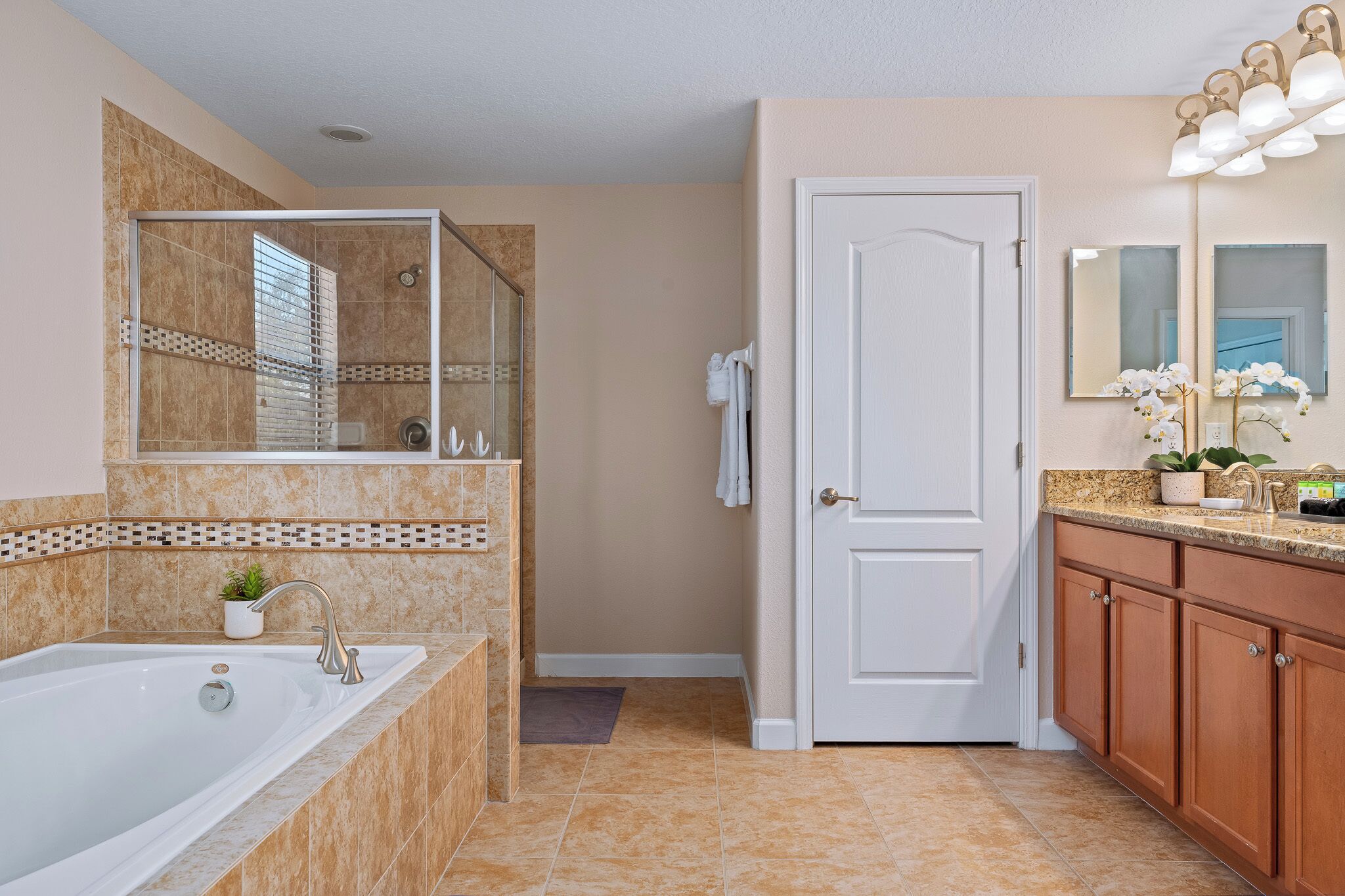 Un baño con bañera, ducha, lavabo y tocador con espejo.
