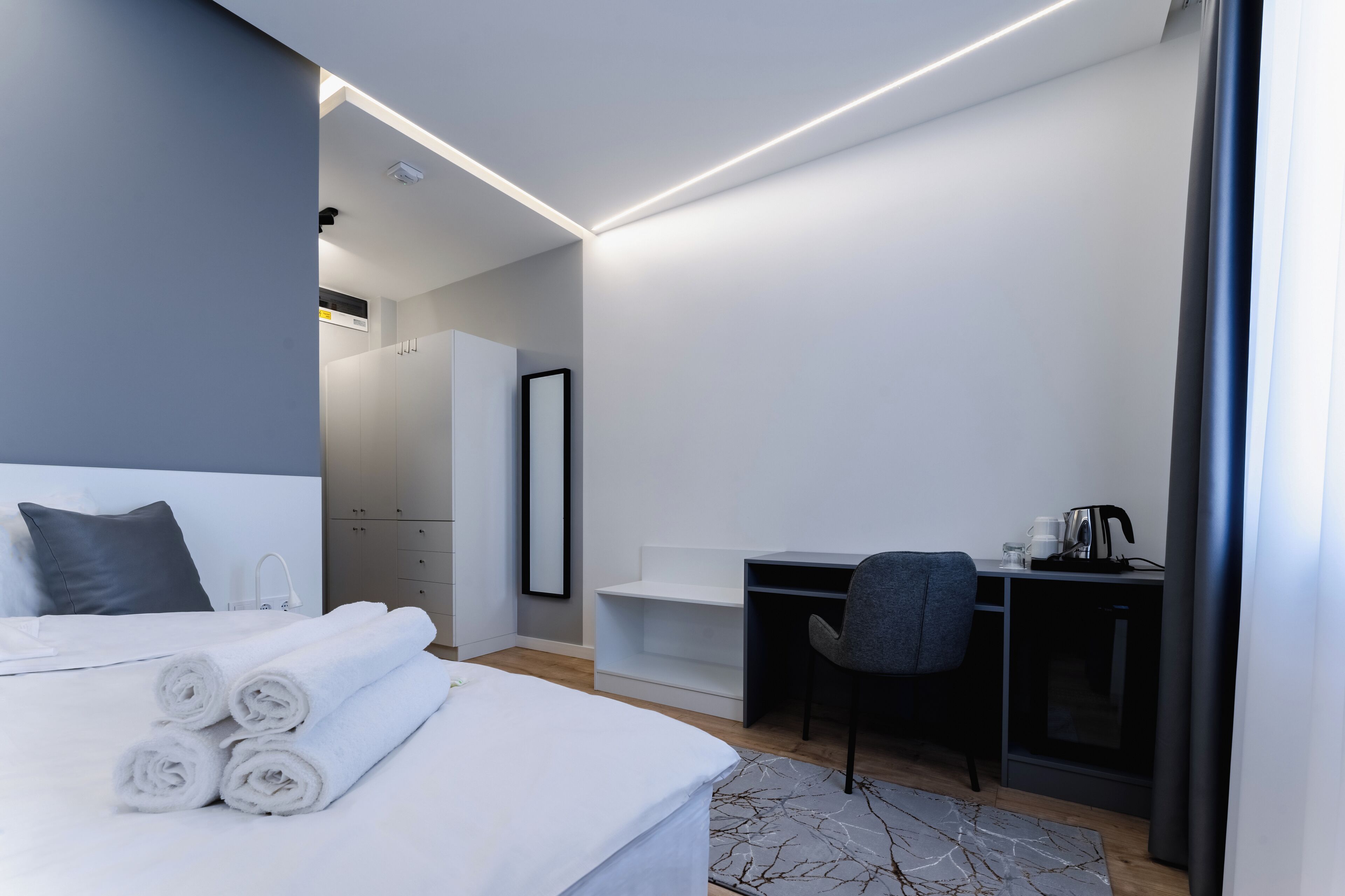 Une chambre d’hôtel moderne avec un lit bien fait, un bureau et une chaise.
