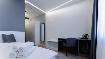 Une chambre d’hôtel moderne avec un lit bien fait, un bureau et une chaise.