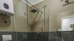 Un baño moderno con ducha de vidrio, inodoro y lavamanos.