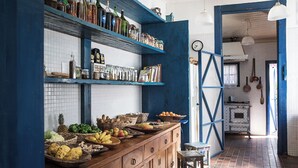 Eine Küche mit Holzausstattung, einer blauen Wand und Regalen mit unterschiedlichen Gegenständen.