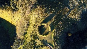 An aerial view of a circular clearing surrounded by dense forest. - FAZENDA CATUÇABA (São Luiz do Paraitinga)