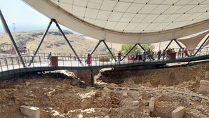 Un sitio arqueológico con ruinas visibles y un corredor cubierto.