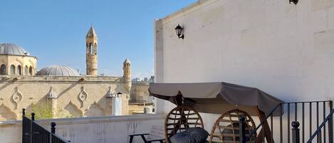 Una terraza en la azotea con vistas a edificios históricos, incluyendo una torre y cúpulas.