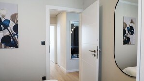 Ein modernes Hotelzimmer mit einem Bett, einem großen Spiegel und Kunstwerken an den Wänden.