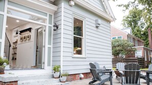 Een huis met een veranda, buitenmeubilair en een fundering van baksteen.