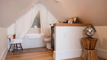 A small, cozy bathroom with a shower, a toilet, a vanity, and a fan.